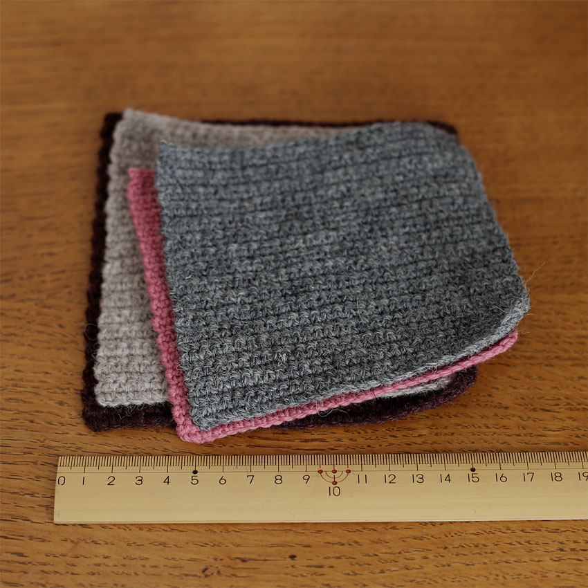 定規の横に並べられた、異なる毛糸で編んだスワッチ（試し編み）。糸の太さやゲージの近さを確認する様子。