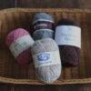 カゴの中に並んだ異なる種類の毛糸玉。代用できる太さの近い糸を探すための比較イメージ。