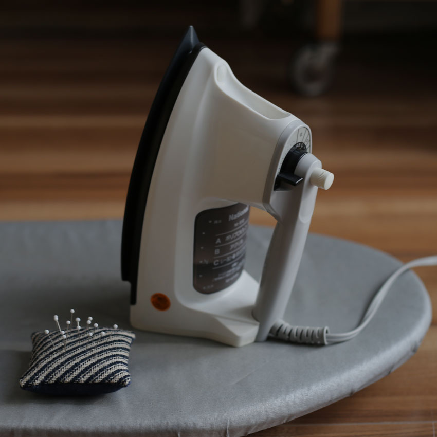 かぎ針編みの編み地のそり返りを直すスチームアイロン。形を整える前の編み地と道具