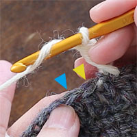 長編み交差[1] 糸をかけ、前段の目を1つ（黄色印）とばして、その次の目（青印）に針を入れます。