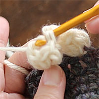 長編み5目のパプコーン編み[5] 針先のループを、もう一方のループにくぐらせます。