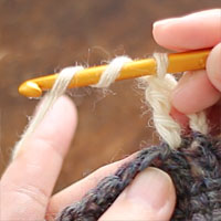 長々編み2目一度[1] 針に糸を2回巻き、前段の目に針を入れます。