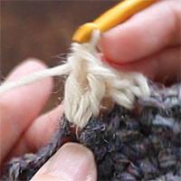 前段の目を束にすくって長編み5目編む[4] 同じところに針を入れて、2目めの長編みを編みました。
