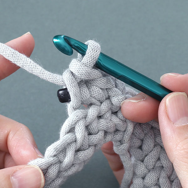 かぎ針編みで、ビーズを編み込んだすじ編みをする方法-4つ目のステップは針にかけた糸を2つのループから引き出す。1目編めました。
