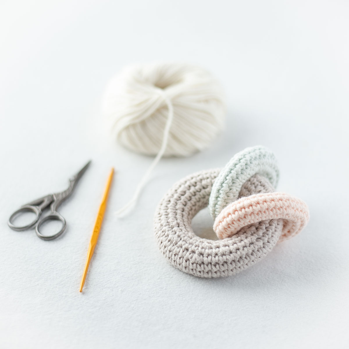 パステルカラーのコットン糸で編むかぎ針編みのラトル。製作途中の風景。