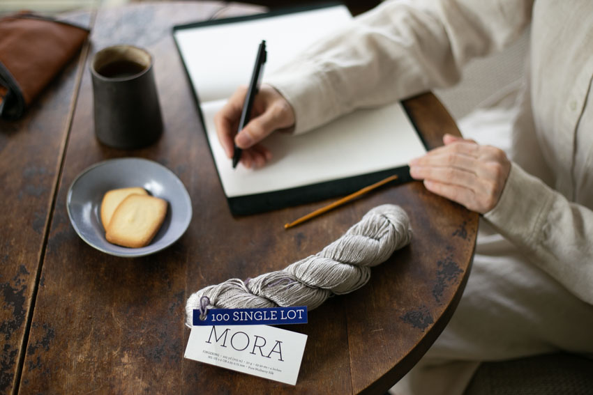 マラブリゴのシルク糸「MORA」かせ糸。１かせを余さず使って編めるかぎ針編み作品を考え、ノートにメモ。
